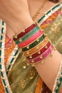 The Ultimate Guide to Kashmiri Bangles: Designs, Styling Tips & Why They Are Trending Close-up of colorful Kashmiri thread-wrapped bangles with small ghungroo bells on a woman