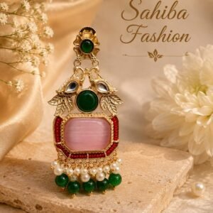 Statement traditional earrings featuring a large soft pink rectangular stone framed with red bead detailing, rich green stones, intricate golden leaf and peacock-inspired motifs, delicate pearl accents, and hanging green beads. The ornate combination creates a vibrant and regal Indian ethnic jewellery look.