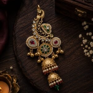 Golden heavy statement earrings with green and pink stones, pearl detailing and double jhumka drops