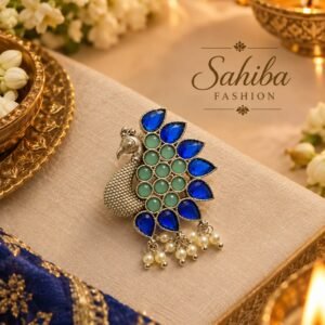Silver-finish peacock brooch embellished with mint green and royal blue stones, accented with hanging pearl beads.